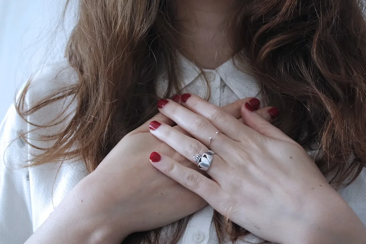 A woman clasping her hands in a calm, reflective moment